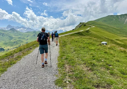 Group of people ascending a rocky trail on a mountain