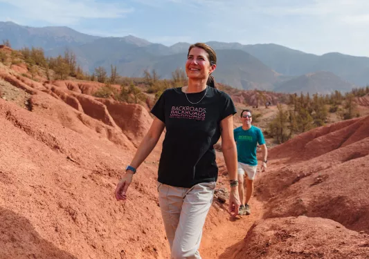 Woman smiling while walking on a trail in a canyon