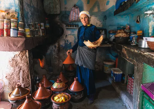 Man uncovering large pots of food
