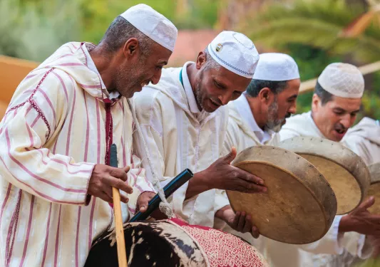 Group of men playing drum-like instruments
