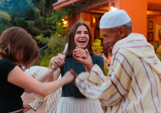 Women smiling while dancing in a circle