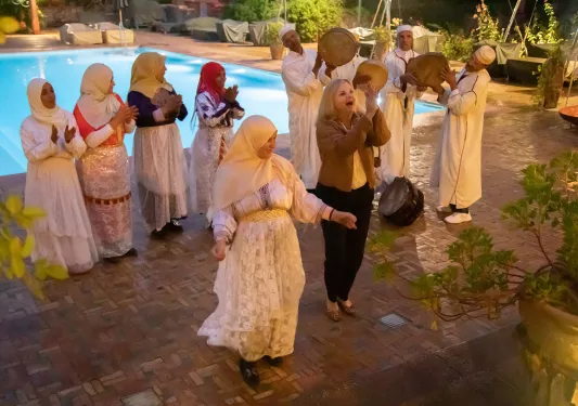 Group of women dancing in front of an outdoor pool