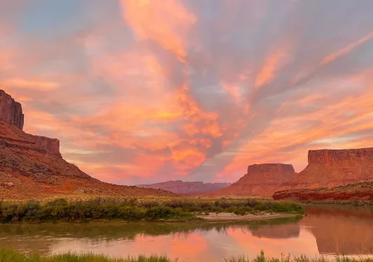 Large valley of tall canyons and mountains, with a river flowing through