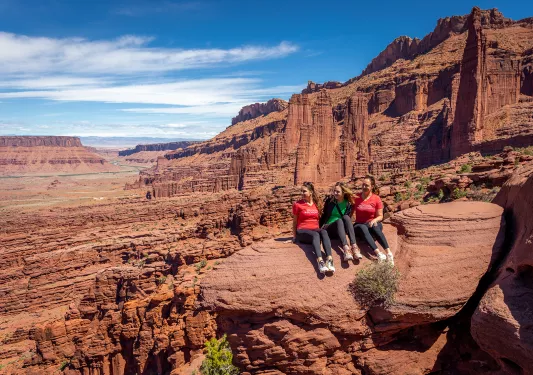Backroads guests sit on a rock in the desert