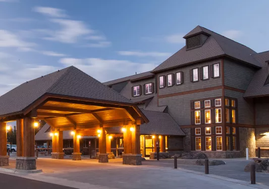 Exterior view of hotel building with large driveway illuminated by warm lights