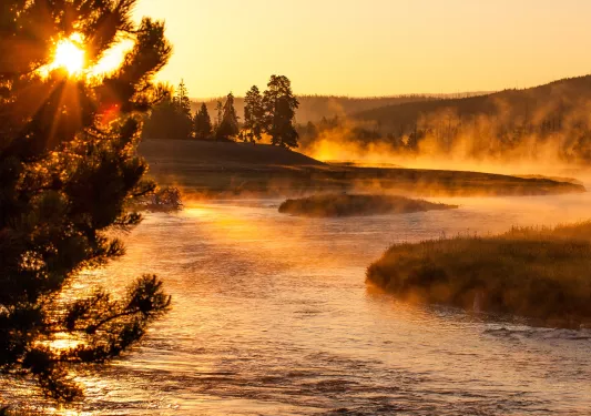 River with fog covering the water, with the sunset in the background