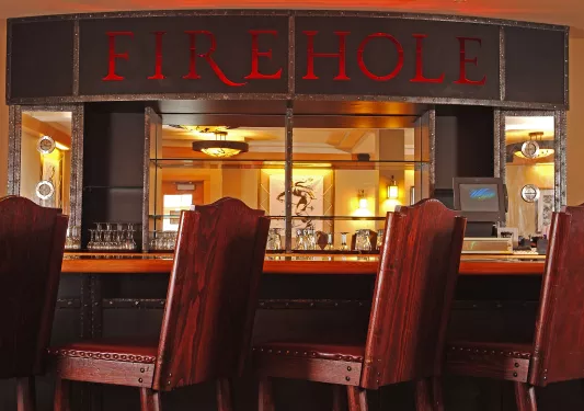 Bar and lounge with wooden stools and a "Firehole" sign above the bar counter