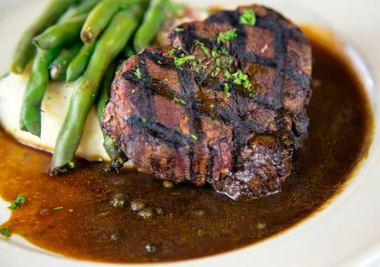 Plate with a grilled steak, peas and mashed potatoes
