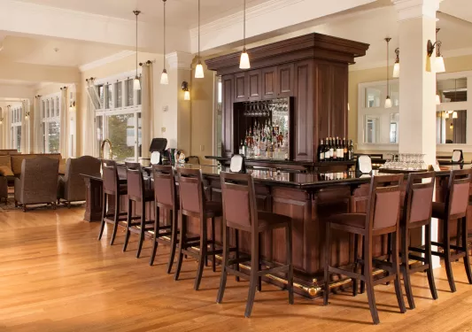 Bar and lounge with a center shelve full of alcohol bottles and spirits