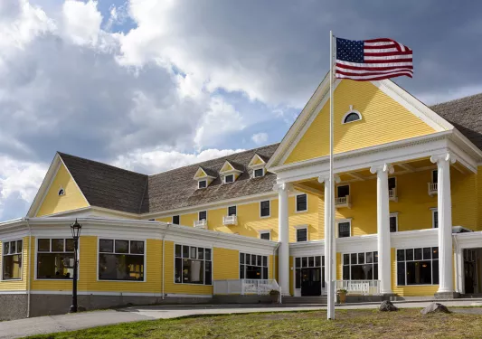 Exterior view of yellow building with an American flag on a flagpole