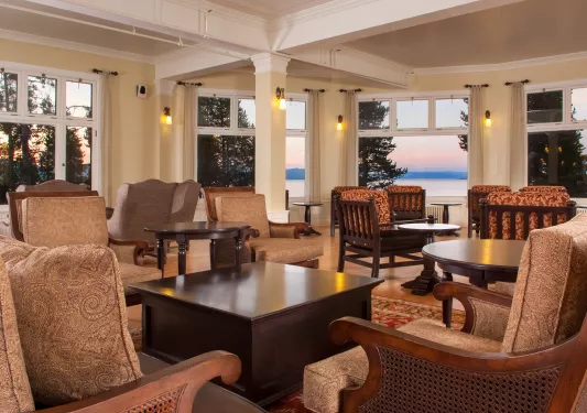 Indoor seating area and lounge with cushioned chairs and dark brown tables