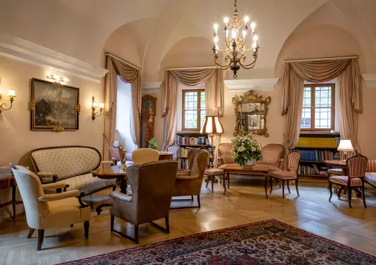 Indoor seating area and lounge with cushioned chairs and mini libraries along the wall