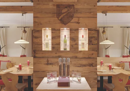Dining hall with exposed wood walls and wine bottles on shelves