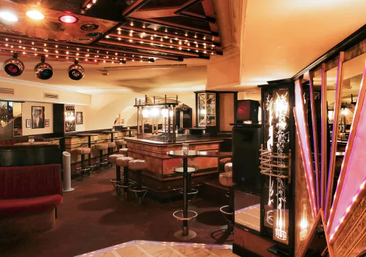 Bar and lounge with leather stools and dimly lit tables