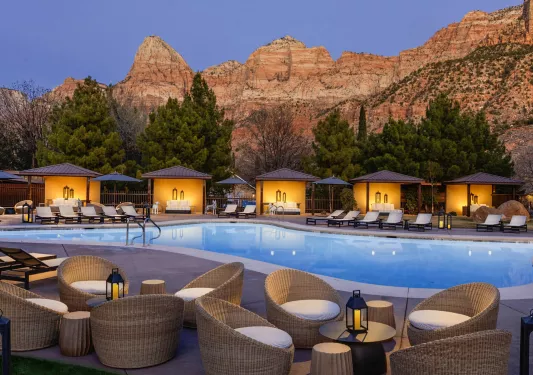 Outdoor pool with woven chairs and pool beds surrounding