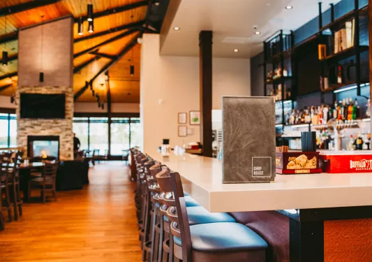 Bar and lounge with white counter and alcohol on shelving along the walls