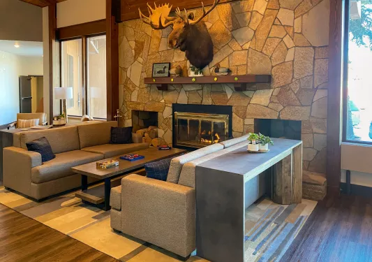 Stone wall with a fireplace and two beige couches in front