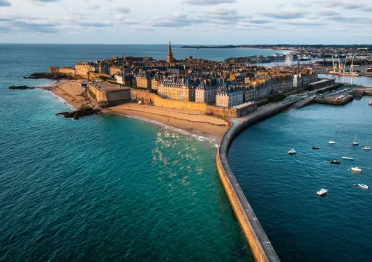 Peninsula town with rustic, European buildings, surrounded by the ocean
