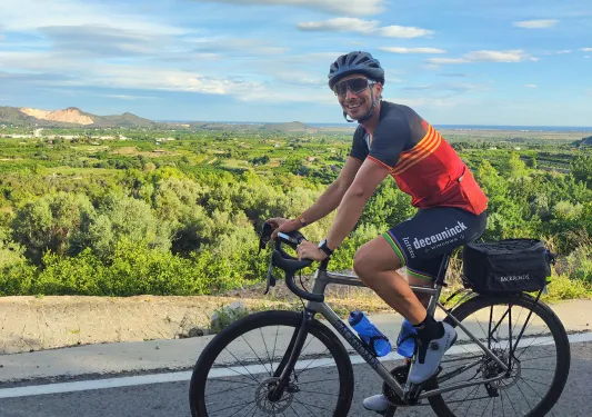 Man biking on a road with a large valley in the background