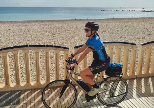 Woman biking next to the beach