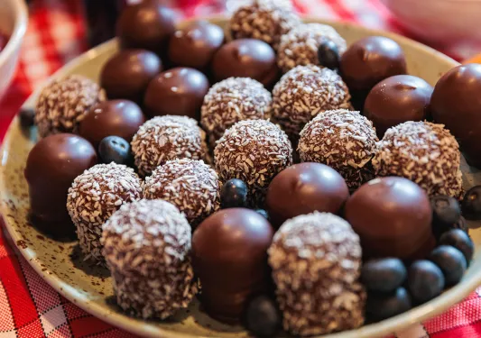 Assortment of chocolates on a small plate, with blueberries sprinkles around