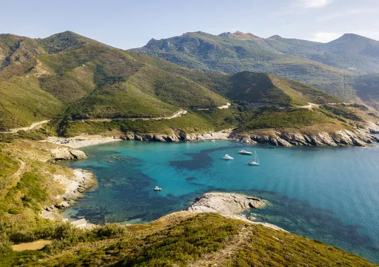 Sky view of a lake with grassy hills surrounding