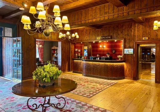 Hotel reception area with a circular table and two men standing behind the counter