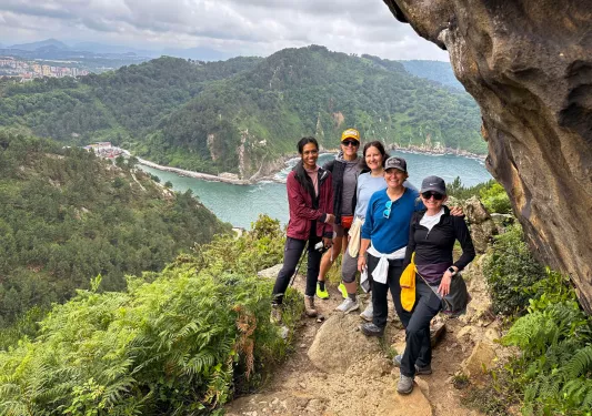 Group of people hiking on a dirt trail with a large river in the background