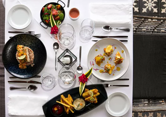 White dining table with plates of food and glasses of water