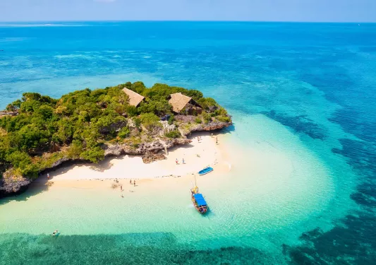 Boat by the ocean coast, with kids playing on the beach
