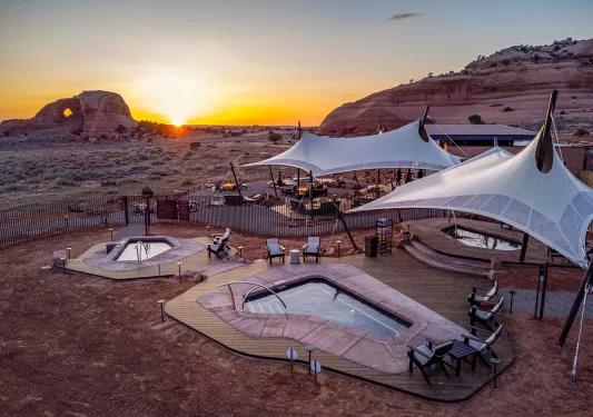Outdoor pools in the middle of a desert with mountains in the distance