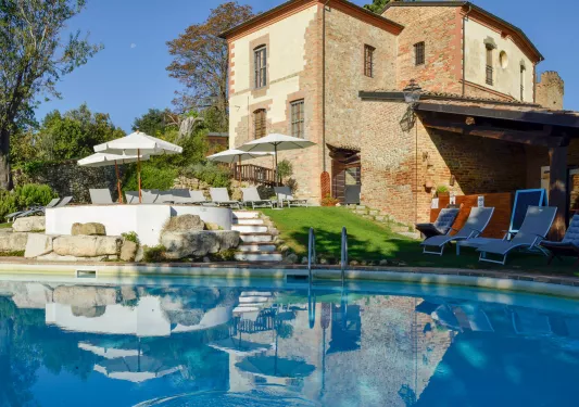 Outdoor pool with a brown, stone building in the background