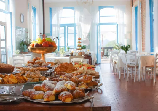 Restaurant with a large table in the center full of pastries and fruit