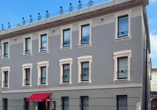 Exterior view of gray hotel building with large windows