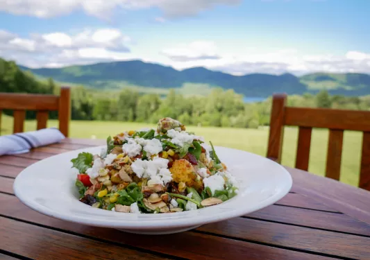 White plate with salad on a wooden table