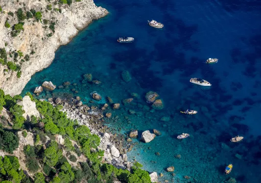 Sky view of boats floating in the ocean by the coast