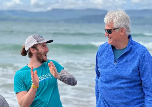Man clapping while an older man is looking and smiling