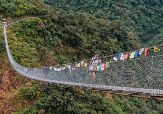 Long, wooden bridge with a woman smiling while walking across