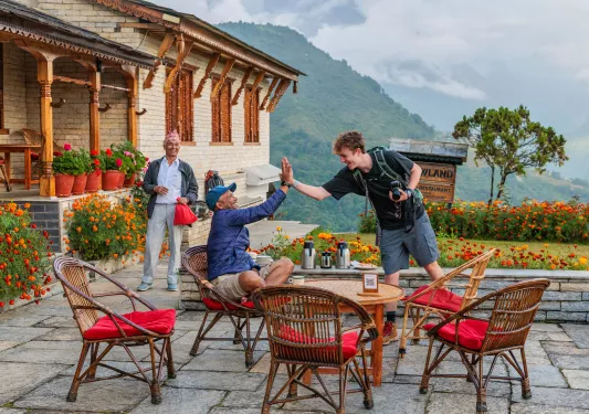 Two men high-fiving with a large forest in the distance