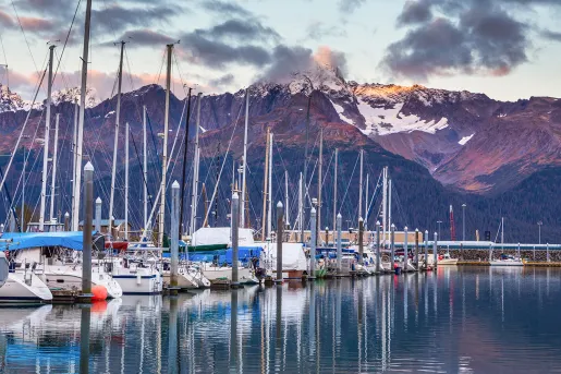 Shot of boat line at pier during sunset, mountain in distance.