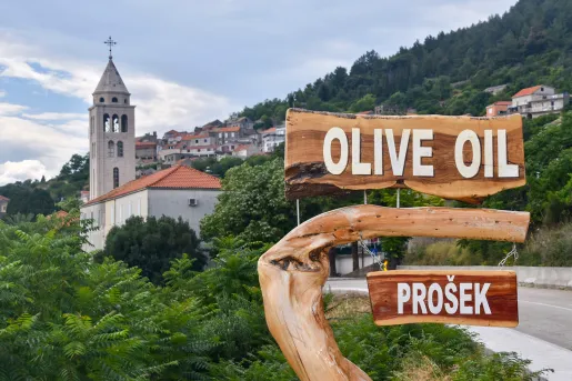 Shot of Croatian hillside town, Prosek, and 'Olive Oil" sign.