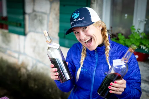 Leader with wine bottles, smiling at camera.