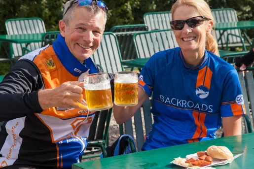 Two bikers having beer and sausages.  
