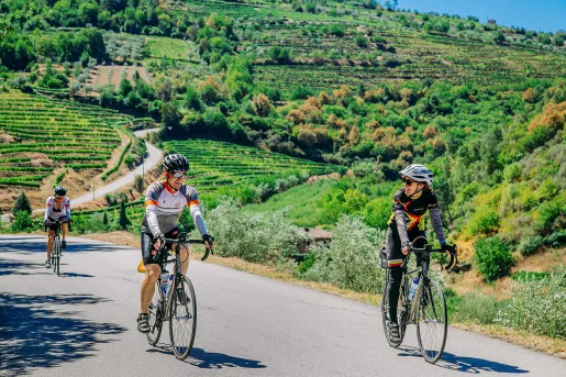 Three bikers riding on a road along the Douro River.