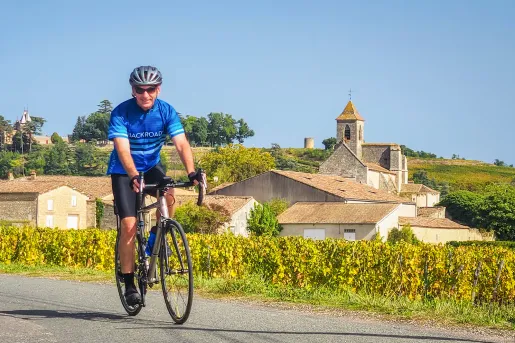 Guest cycling past small French countryside town.