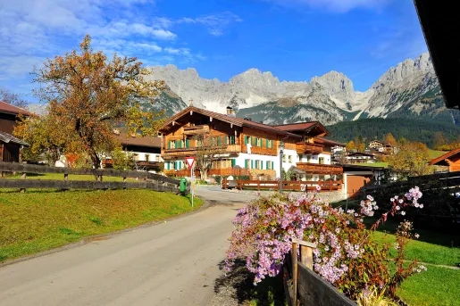 Wooden lodge hotel with mountains in background.