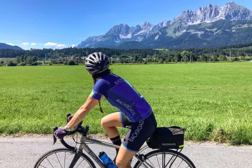 Backroads biker riding on road with Tyrolean Alps in background.