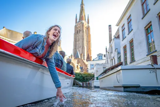 Guest dipping hand in water on boat