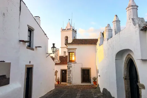 Walkway shot of white walled village during sunset.