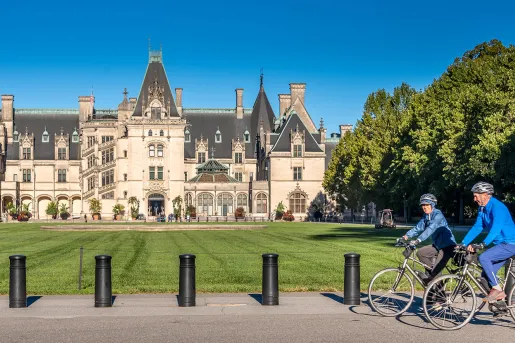 Guests biking in front of the Biltmore Estate.